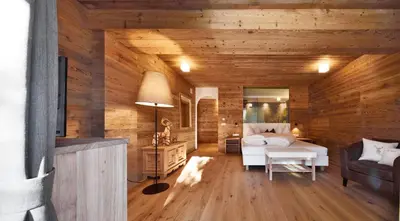 a bedroom with wooden walls and a bed in a room at Villa Schmalzl in Ortisei