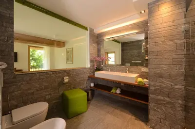 a bathroom with a tub and a large mirror at Villa Schmalzl in Ortisei