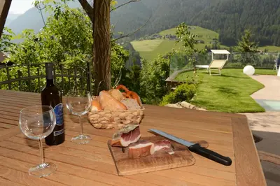 a table with a basket of bread and a bottle of wine at Villa Schmalzl in Ortisei