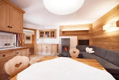 a kitchen and living room with a bed and a couch at Villa Schmalzl in Ortisei