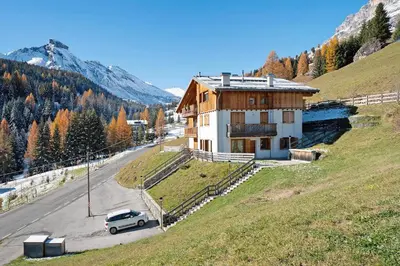 a car parked in front of a house on a hill at Sunny Arabba Apartment in Arabba
