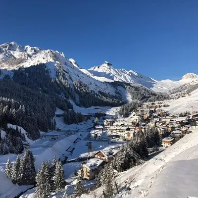 a village in the snow with mountains in the background at Sunny Arabba Apartment in Arabba