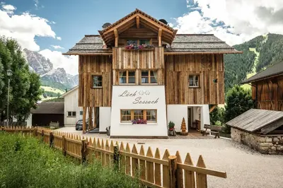 a wooden house with a fence in front of it at Natur Luch Sossach in La Villa