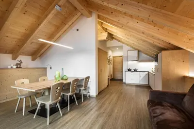 a kitchen and dining room with a wooden table and chairs at Natur Luch Sossach in La Villa