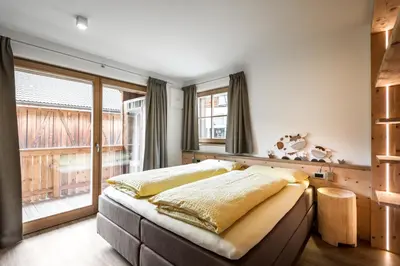 a bedroom with a bed and a large window at Natur Luch Sossach in La Villa