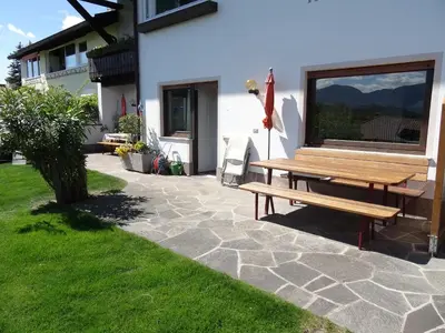 a wooden picnic table sitting next to a house at Haus Marion in Appiano sulla Strada del Vino