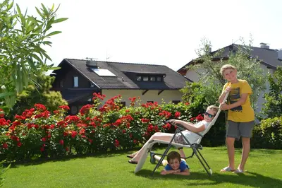 a man and a woman standing in a lawn chair with a child at Haus Marion in Appiano sulla Strada del Vino