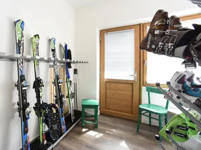 a room with a bunch of skis hanging on a wall at Garní Emma in Arabba