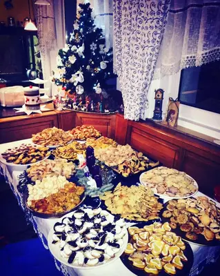 a table with many plates of food and a christmas tree at Garní Emma in Arabba