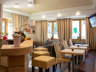a restaurant with tables and chairs and windows at Garní Emma in Arabba