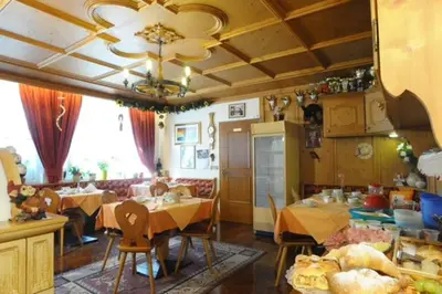a kitchen and dining room with tables and chairs at Garní Emma in Arabba