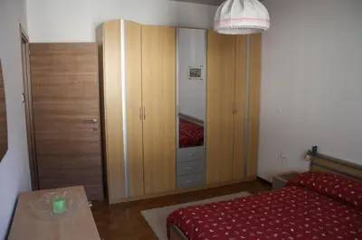 a bedroom with a closet and a bed and a table at Guesthouse48 in Bolzano