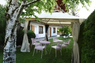 a table and chairs under a tent in a yard at B&B Magiré in Tesero