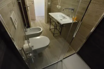 a bathroom with two sinks and a glass shower at B&B Magiré in Tesero