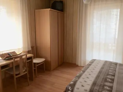 a bedroom with a desk and a bed and a table at Garnì Serena in Canazei