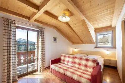 a bedroom with a bed and a large window at Gasthof Specker in Obereggen