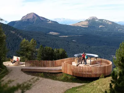 a person standing on top of a mountain with mountains in the background at Gasthof Specker in Obereggen