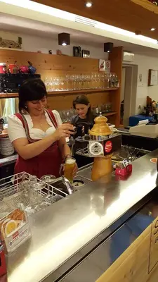 two women standing in a kitchen preparing food at Gasthof Specker in Obereggen