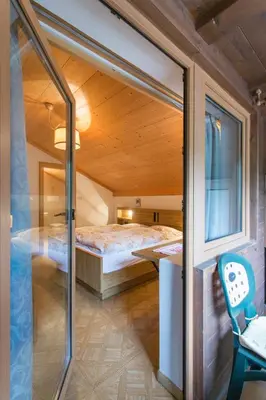 a small room with a bed and a glass door at Gasthof Specker in Obereggen