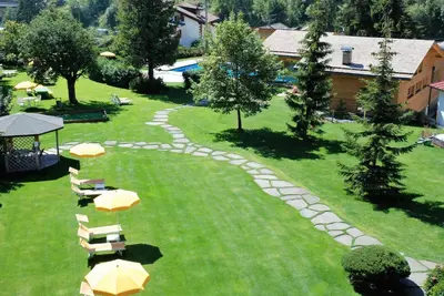 an overhead view of a lawn with chairs and umbrellas at Residence Comploj in Santa Cristina in Val Gardena