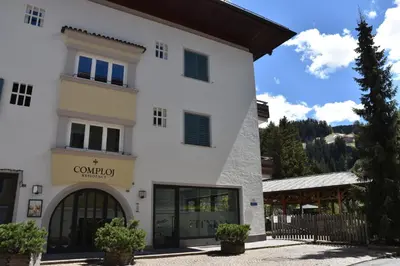 a white building with a sign that reads comedia at Residence Comploj in Santa Cristina in Val Gardena