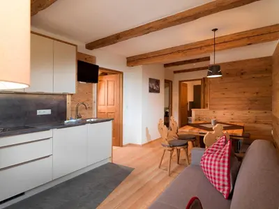 a kitchen and living room with a couch and a table at Bruggerhof Prags in Braies