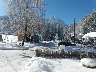 a fence covered in snow with mountains in the background at Bruggerhof Prags in Braies