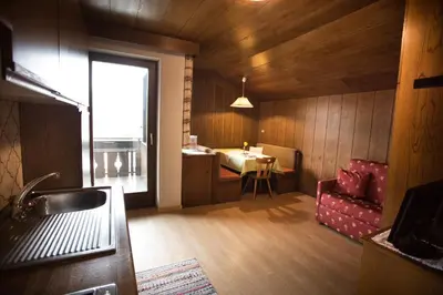 a room with a table and a chair and a kitchen at Residence Rienz in Chienes