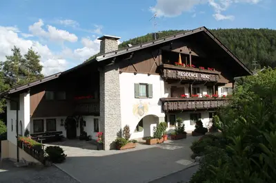 a large white building with flowers in front of it at Residence Rienz in Chienes