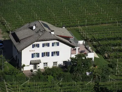 an aerial view of a white house in a field at Rebhof Kaltern in Caldaro