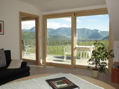 a living room with a sliding glass door with a view at Rebhof Kaltern in Caldaro
