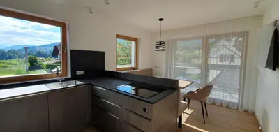 a kitchen with a sink and a large window at B&B Haus Grüner in Valdaora