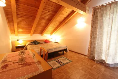 a bedroom with a bed and a wooden ceiling at Agritur Chelodi in Cavalese