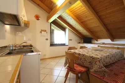 a kitchen with a table and a sink and a counter at Agritur Chelodi in Cavalese