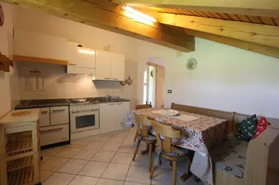 a kitchen with a table and a stove top oven at Agritur Chelodi in Cavalese