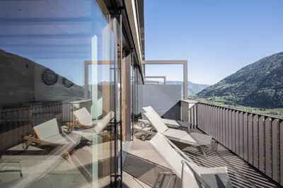 a balcony with white chairs and a view of mountains at Paloria Apartments & Sport in Lagundo