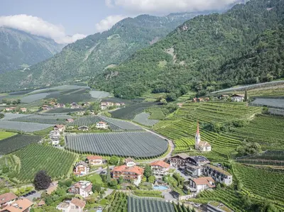 an aerial view of a village in a valley with mountains at Paloria Apartments & Sport in Lagundo