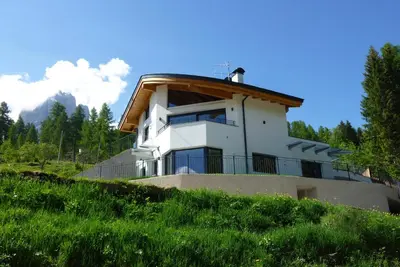 a house on top of a grassy hill at Arpa Chalet in Santa Cristina in Val Gardena
