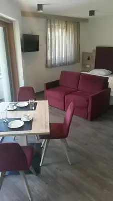 a living room with a red couch and a table at Arpa Chalet in Santa Cristina in Val Gardena