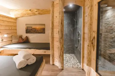 a bedroom with a shower and a bed with towels at Wegscheiderhof in Feldthurns