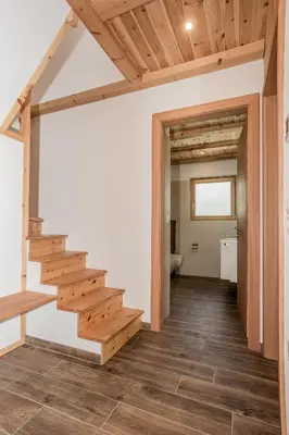a hallway with wooden stairs in a house at Wegscheiderhof in Feldthurns