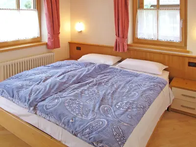 a bedroom with a bed with a red blanket at Apartment Giovanni - CPO359 by Interhome in Campitello