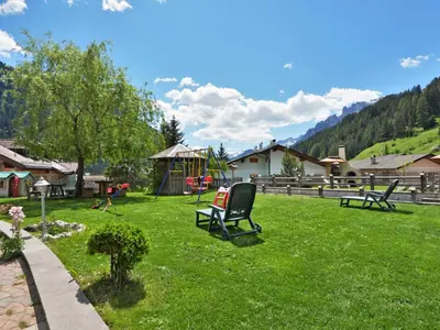 a fence with a picnic table and an umbrella at Apartment Cecilia-2 by Interhome in Campitello