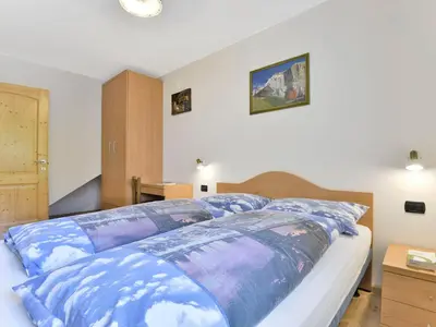 a bedroom with a large bed with blue sheets at Apartment Cecilia-2 by Interhome in Campitello