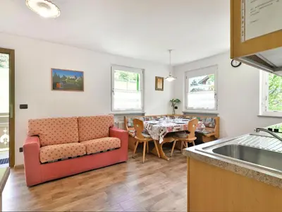 a bedroom with a bed and a night stand next to it at Apartment Cecilia-2 by Interhome in Campitello