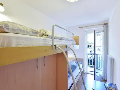 a bedroom with a bed and a table and a chair at Apartment Cecilia-2 by Interhome in Campitello