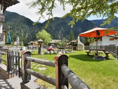 a fence with a picnic table and an umbrella at Apartment Cecilia-4 by Interhome in Campitello