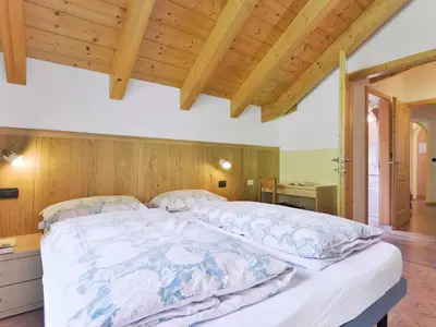 a bedroom with a large bed with a wooden ceiling at Apartment Cecilia-4 by Interhome in Campitello
