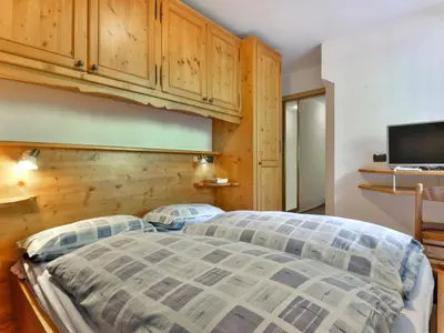 a bedroom with a large bed with a wooden headboard at Apartment Cecilia-5 by Interhome in Campitello