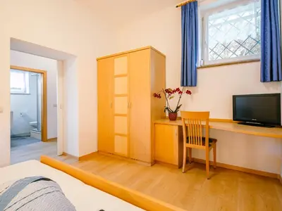 a bedroom with a desk with a television and a chair at Apartment Wolfsthurn by Interhome in Andrian